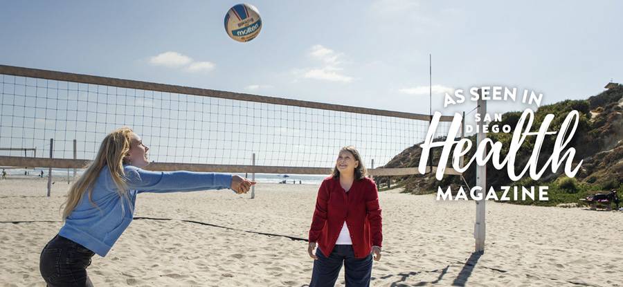 Mother and her daughter playing volleyball on the beach in San Diego.