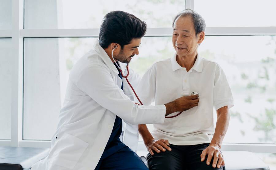 A male physician and a male patient discussing the patient's health, illustrating a Medicare annual wellness visit.