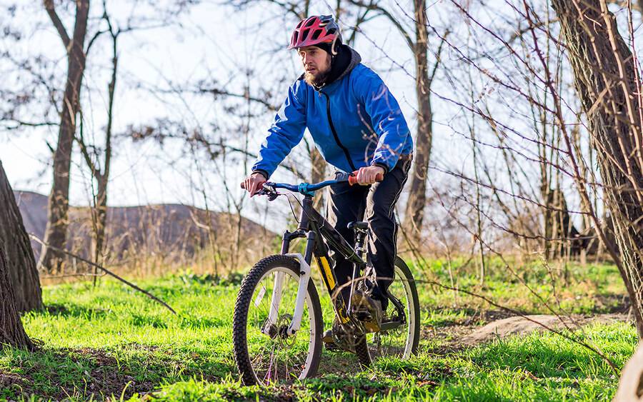 A man mountain biking outside to illustrate exercising more in the New Year.