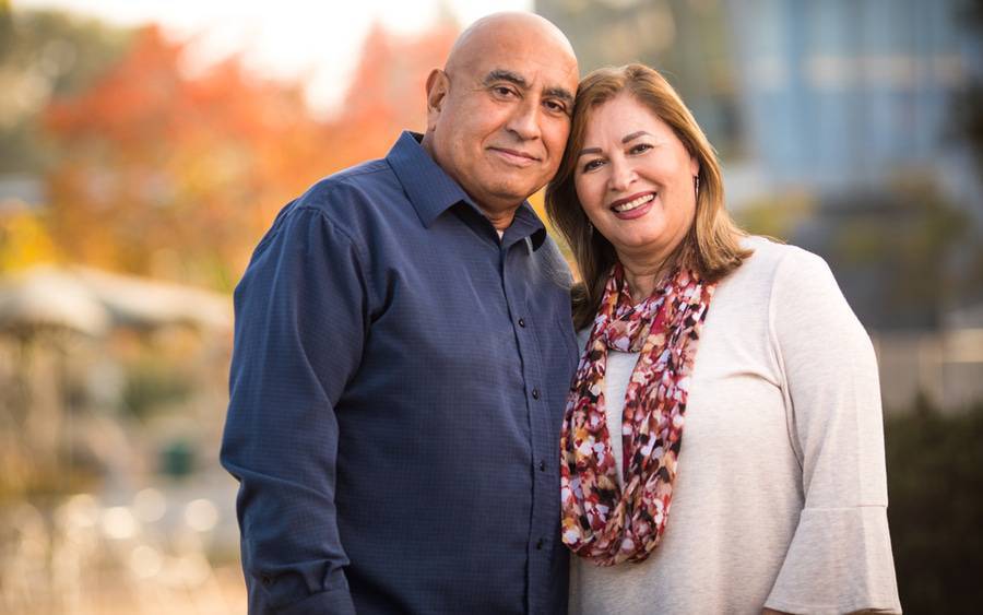 Marco Cisneros, who survived a rare type of lymphoma, stands proudly with his wife following his cancer treatment.