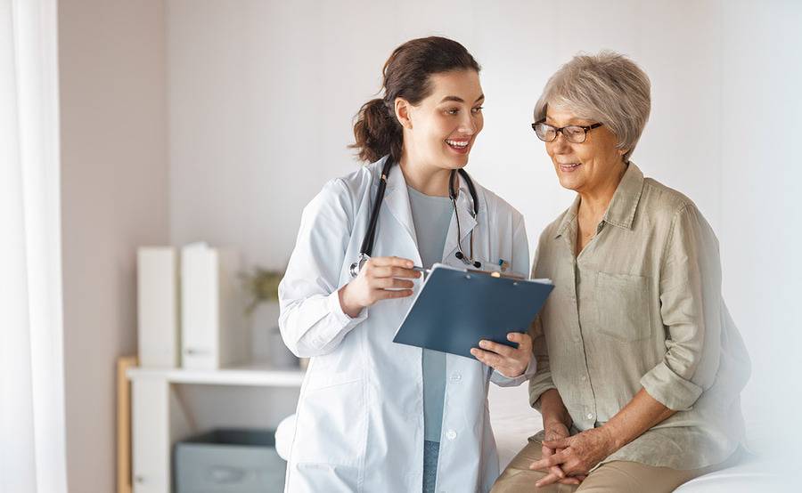 A mature female cancer patient consulting with a female doctor, illustrating the discussion of cancer treatment options.