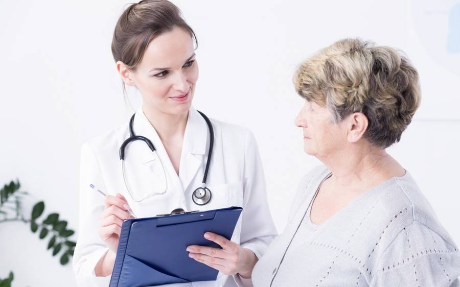 A compassionate doctor visits with an elderly patient, showing why Scripps Clinic and Scripps Coastal earned awards.