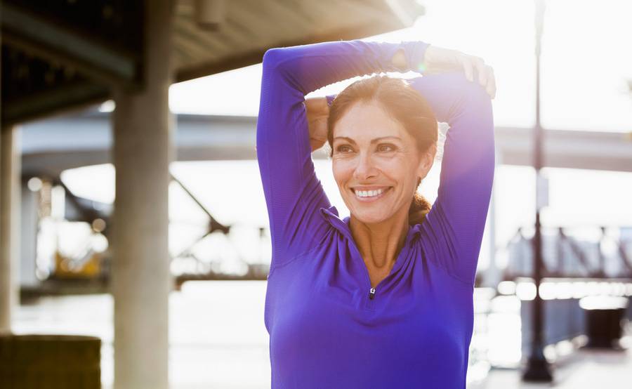 A woman outside stretching, illustrating a healthy woman during menopause.