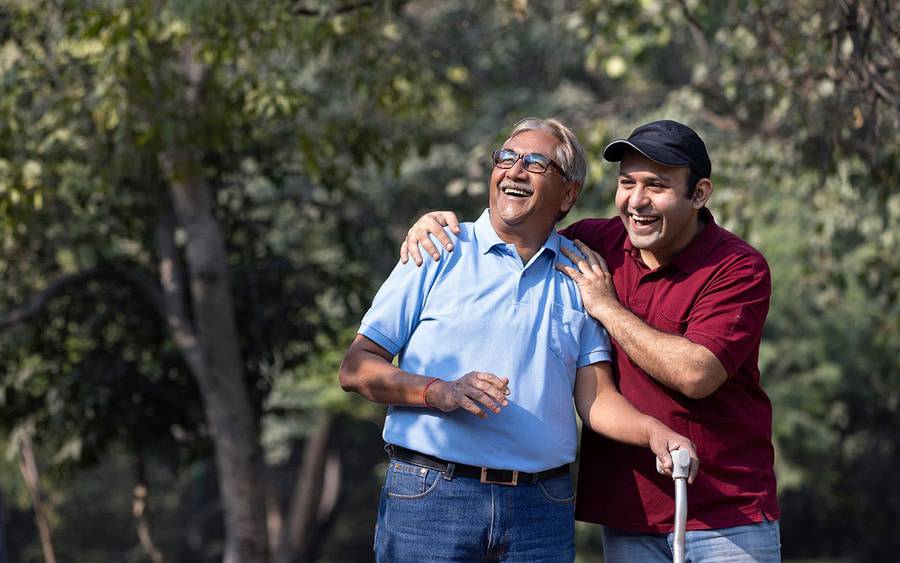 older man with can standing with younger man