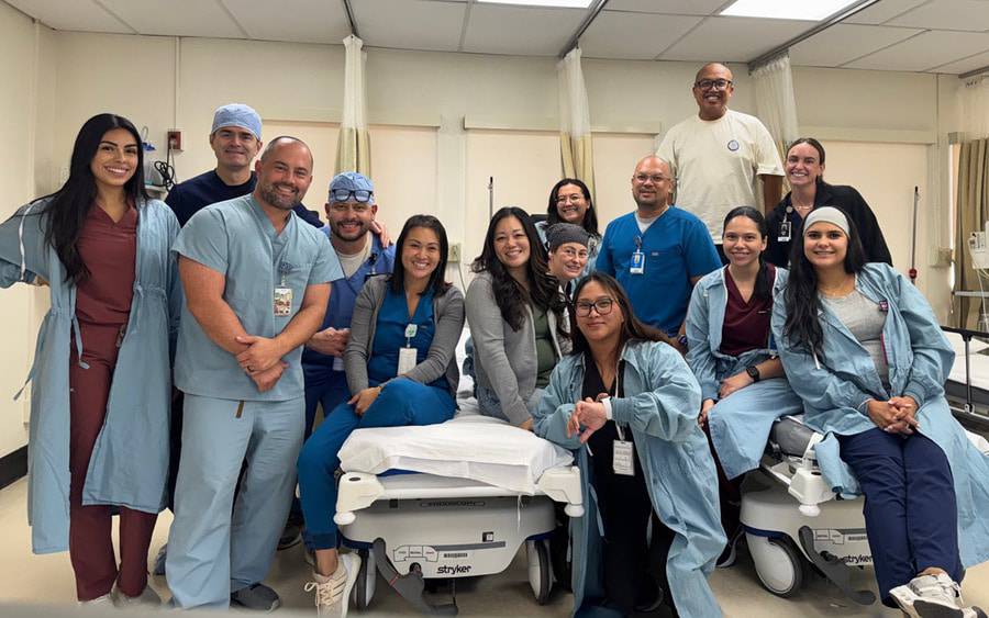 Scripps Mercy Hospital Chula Vista GI nursing staff smile for a picture in a hospital room.