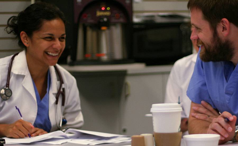 Two family medicine residents share notes over coffee, showing the camaraderie of this close-knit program at Scripps Mercy Chula Vista.