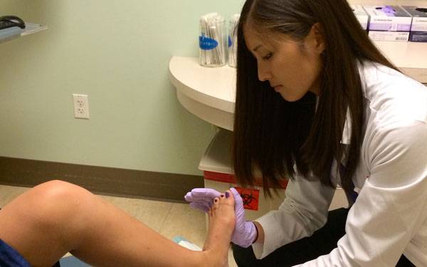 A Scripps resident physician conducts a foot exam as part of her training in podiatric medicine.