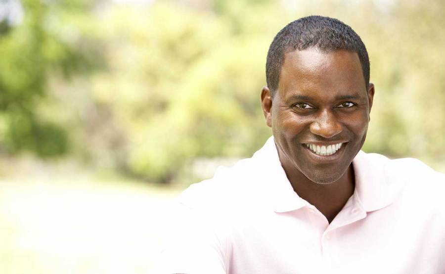 A smiling African-American man represents the full life that can be led after mouth cancer treatment.