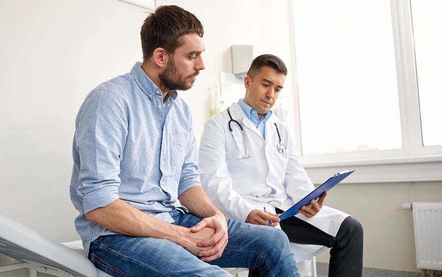 A young man sits and discusses his health with his primary care doctor.
