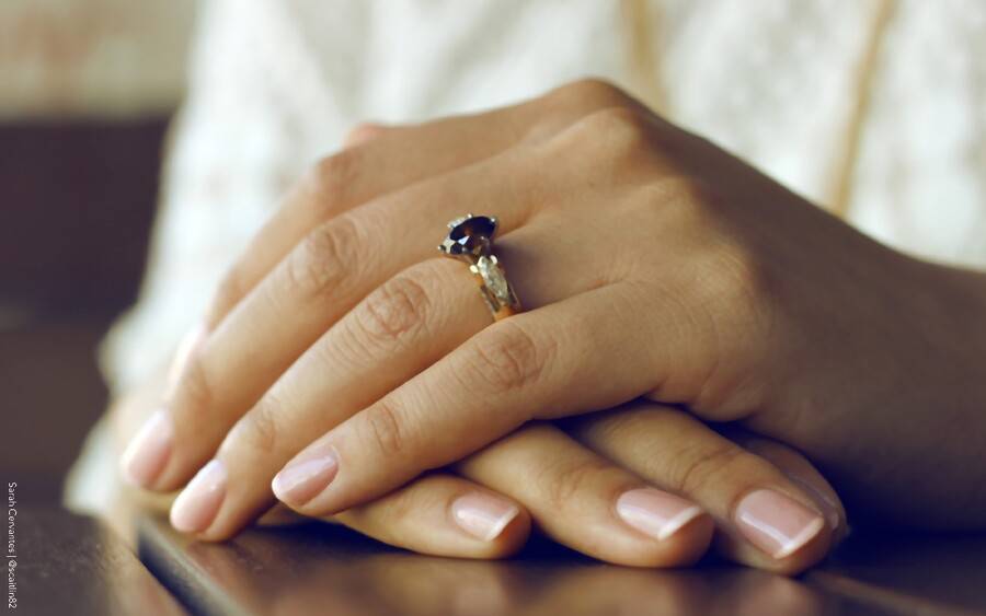 Woman wearing ring showing off her healthy nails.