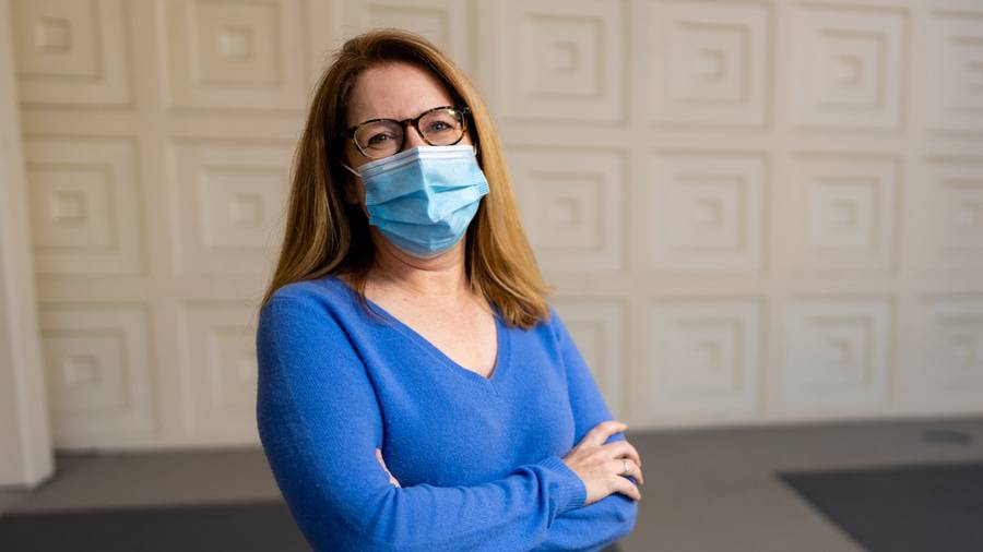 Naomi Junge, RN standing outside in front of a white wall with a face mask on, one of the eight Scripps Nurses of the Year 2020.