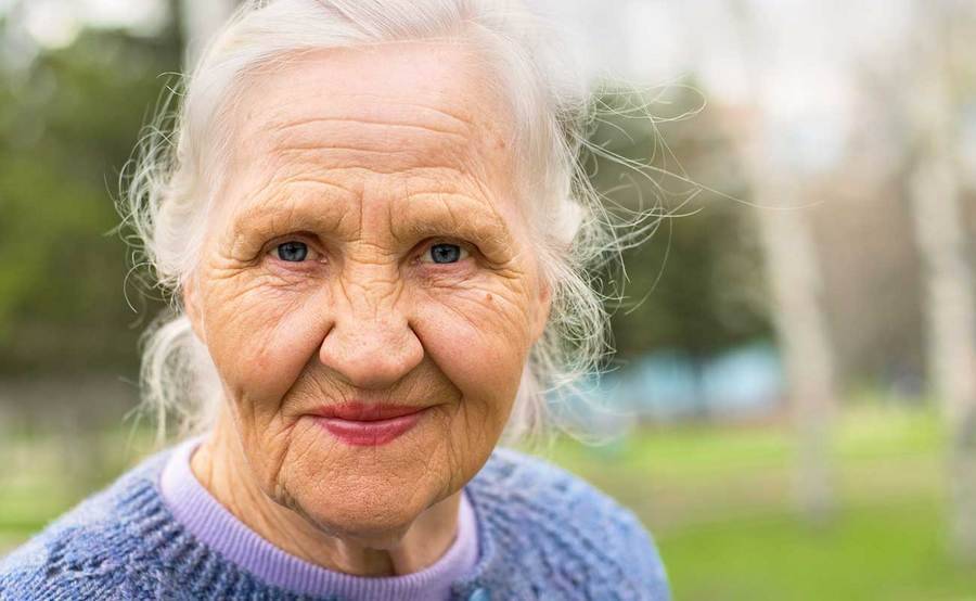 A smiling mature woman represents the full life that can be led after metastatic squamous neck cancer treatment.