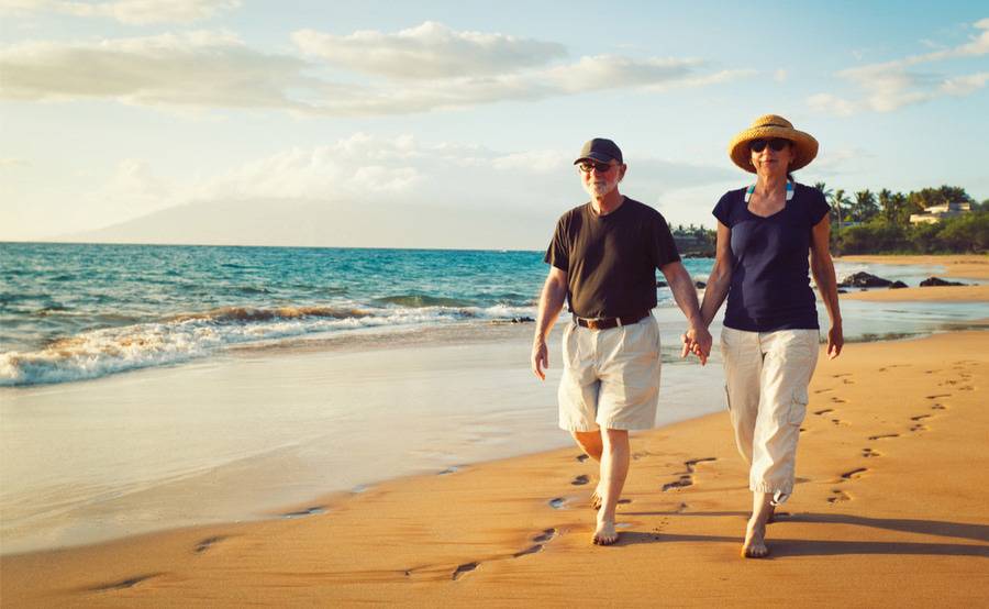 A mature couple walks down the beach, representing the successful management of kidney disease by Scripps nephrologists.