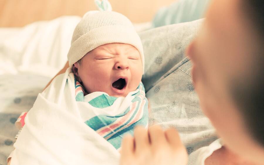 A mother holds her newborn baby in maternity bed at Scripps..