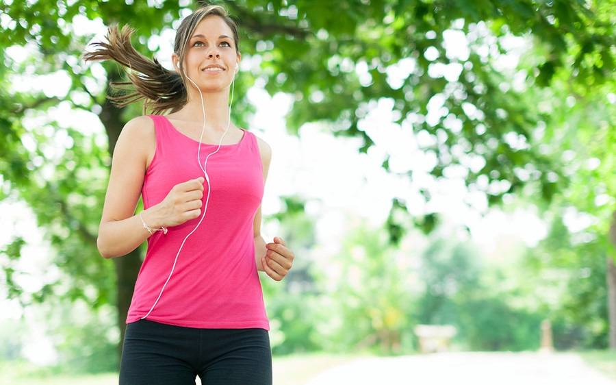 A woman running with her headphone in.
