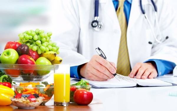 A doctor writes notes with healthy foods in the foreground signifying how a Scripps expert weighs in on a new diet ranking.