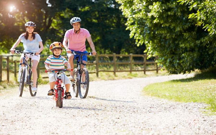 A young family of three ride their bikes along a trail to help prevent childhood obesity.