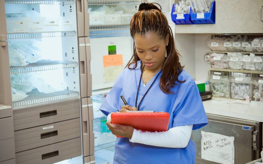 A female nurse takes notes in a hospital supply room, representing coronavirus preparations.