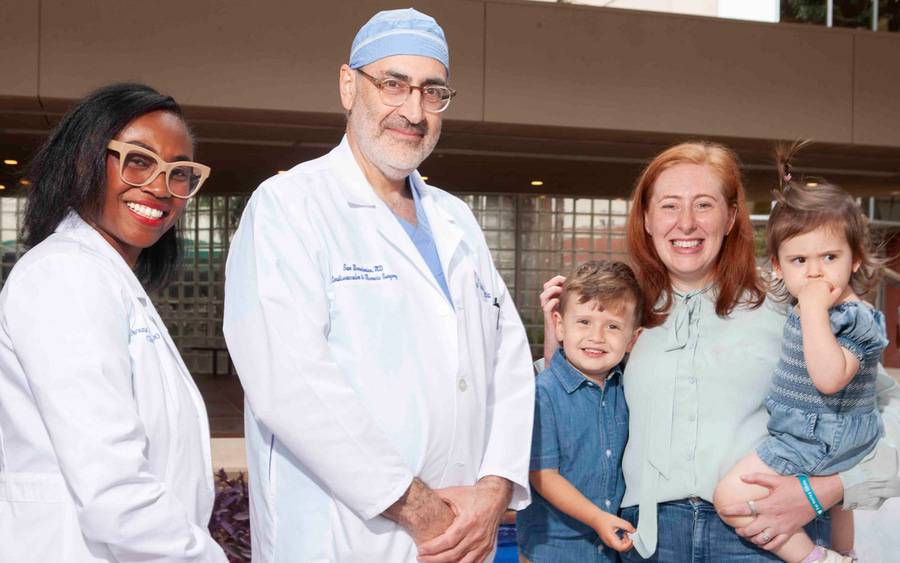 Olivia Smoak is pictured with her children and care team in an outdoor setting.