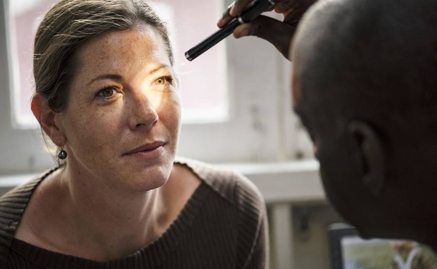 A neuro-ophthalmologist checks a patient's eyes with a penlight, representing the combination of neurology and ophthalmology at Scripps in San Diego.