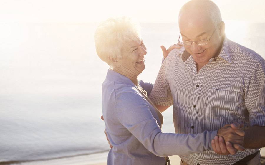 Mature couple slow dancing on the beach