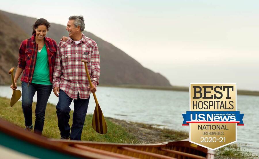 A mature couple prepare to go canoeing following the husband's successful knee replacement surgery.