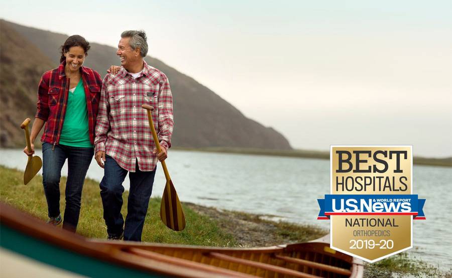 A mature couple prepare to go canoeing following the husband's successful knee replacement surgery.