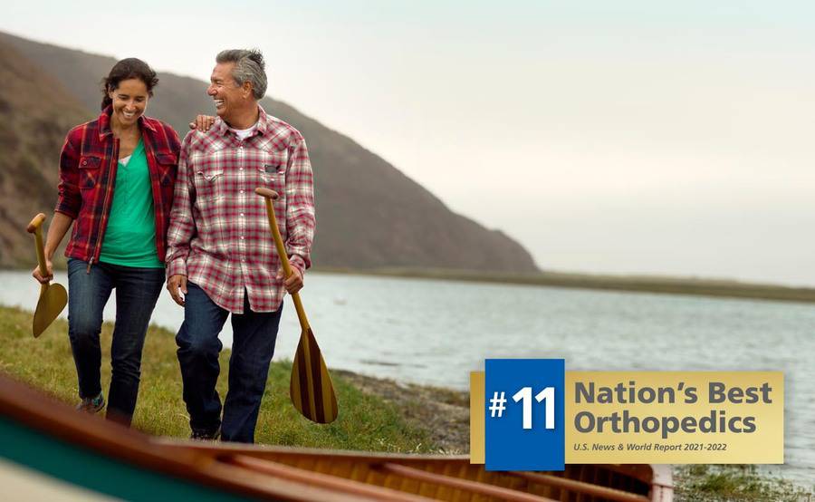 A mature couple prepare to go canoeing following the husband's successful knee replacement surgery.