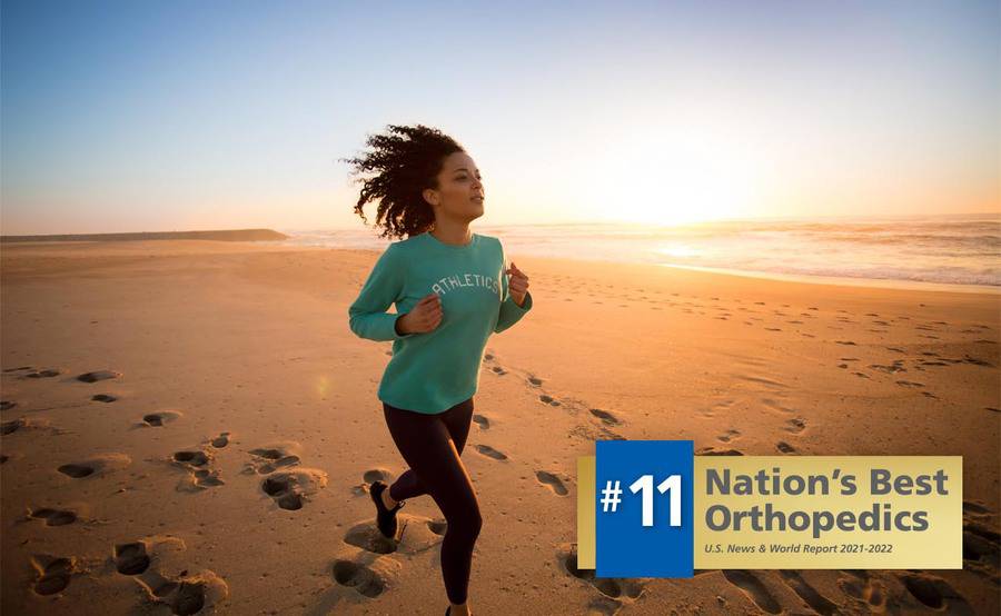 A woman jogs on the beach at sunrise, representing an actively lifestyle after foot or ankle surgery.