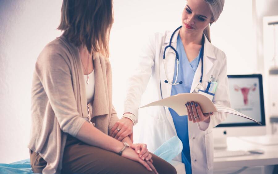 A physician assistant examines a patient.