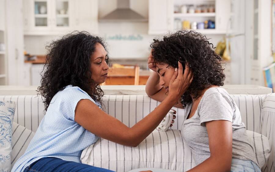 A mother comforts her young daughter in an emotional moment,  one of the top six concerns parents have for kid's health.