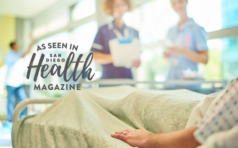 Hospital staff members check on a patient in a hospital bed. SD Health Magazine