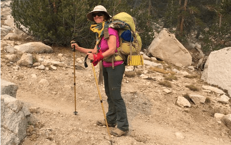 Patti McCarthy uses hiking poles to climb a mountain after her yearlong breast cancer treatments. 