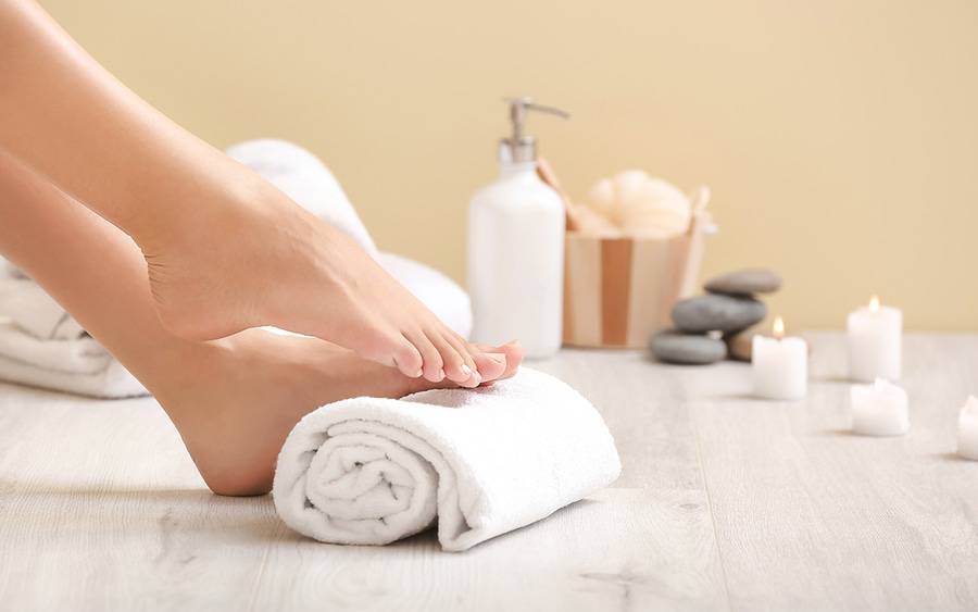 Feet after pedicure, rolling over folded towel.