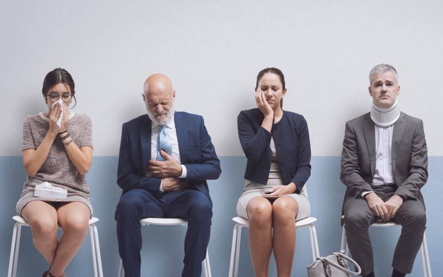A group of people sit in the emergency room waiting to be called.