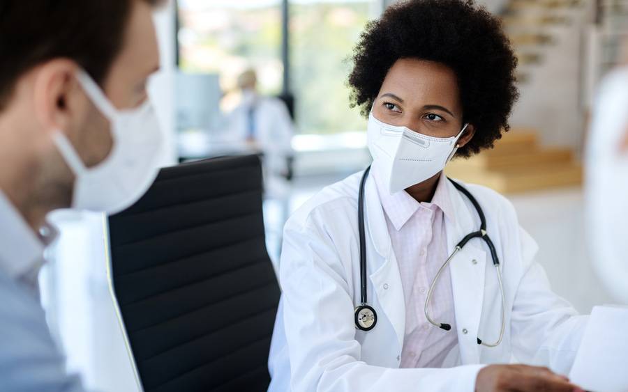 A patient and physician conversing while  at an appointment.