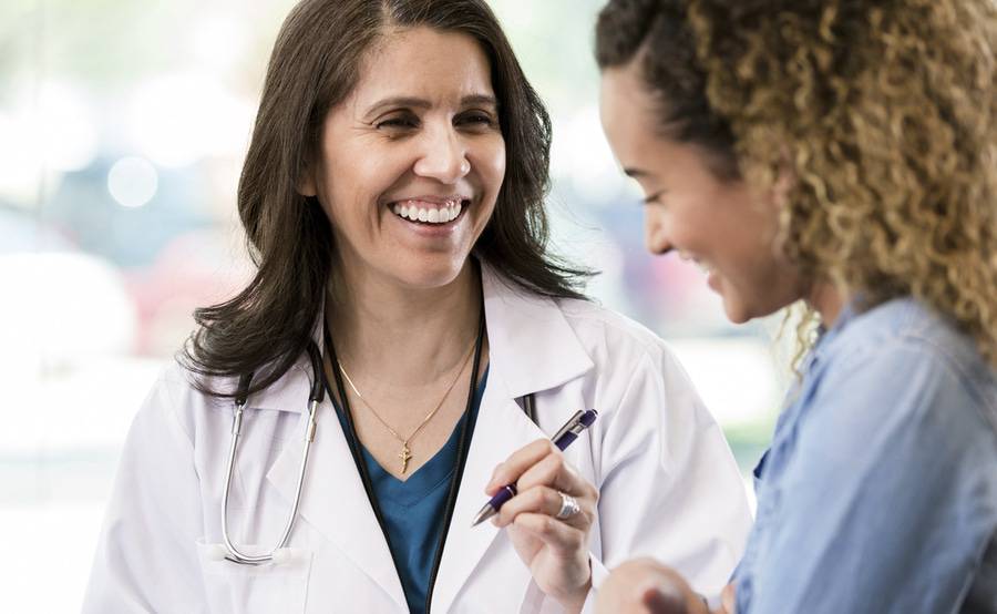 A provider and her patient talking during an exam.