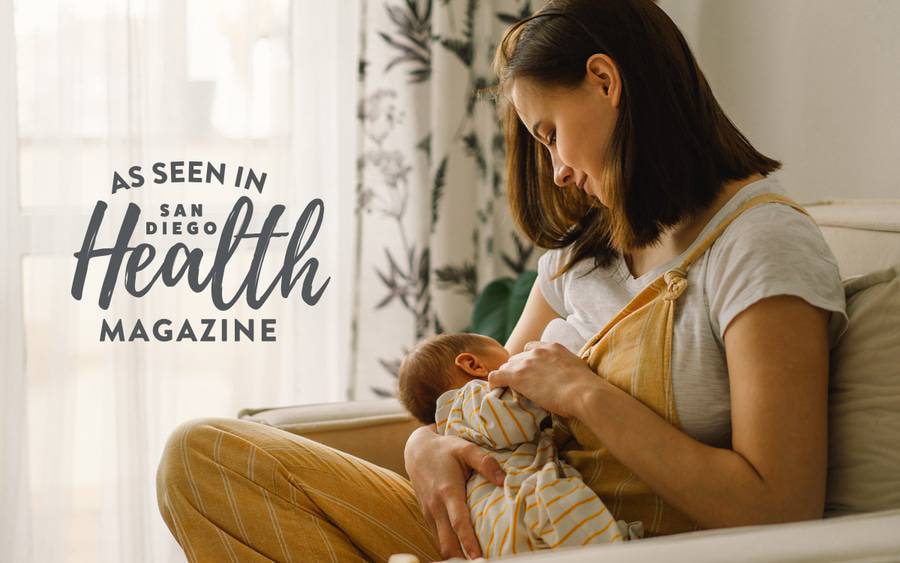 A young mother sits on a chair nursing her new baby - SD Health Magazine