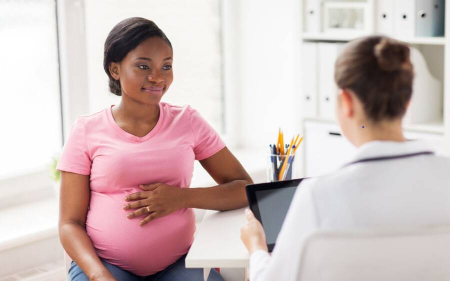 A pregnant woman meets with her doctor to discuss heart issues.