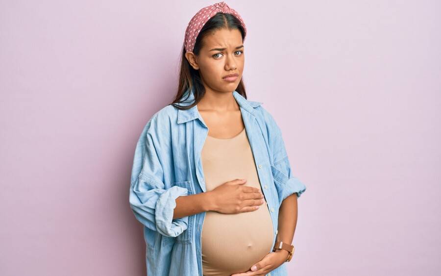 Pregnant woman with unpleasant symptoms that might require urgent care.