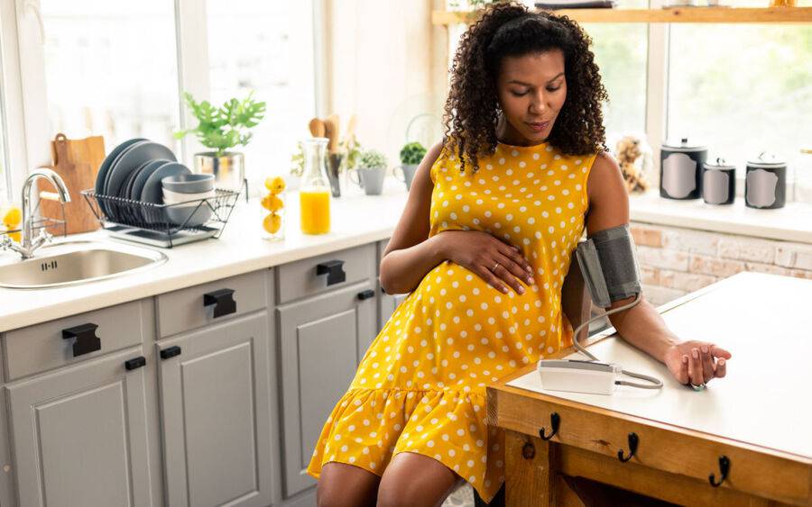 A pregnant woman takes her blood pressure to check for signs of preeclampsia.