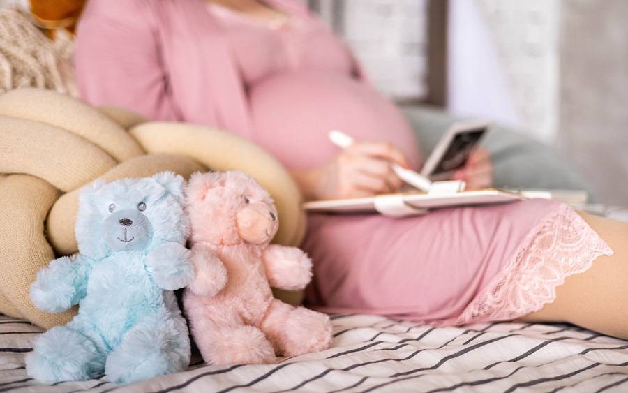 A pregnant woman in bed goes over her birth plan.