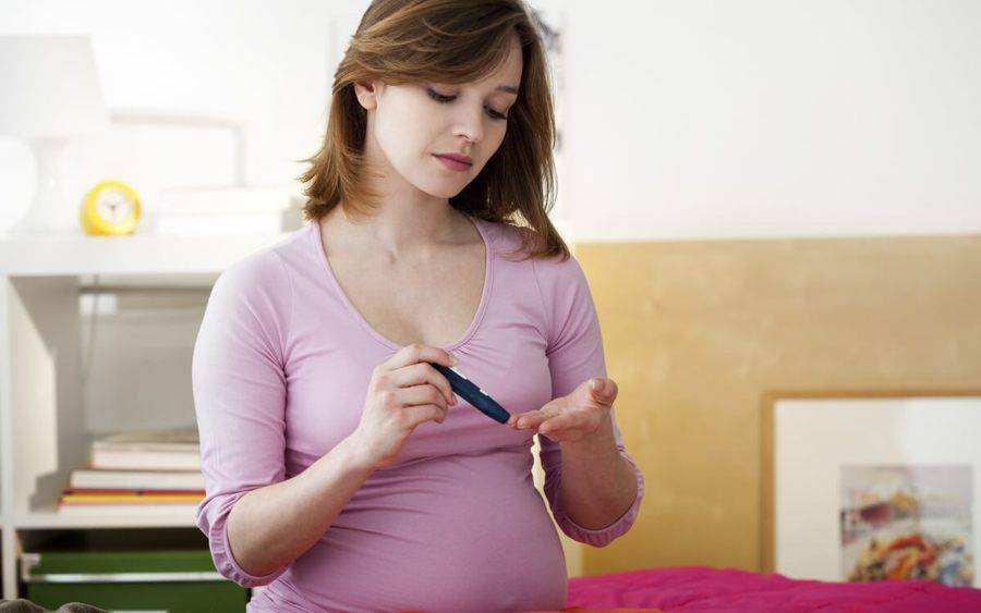 Pregnant woman with diabetes checks her blood level.