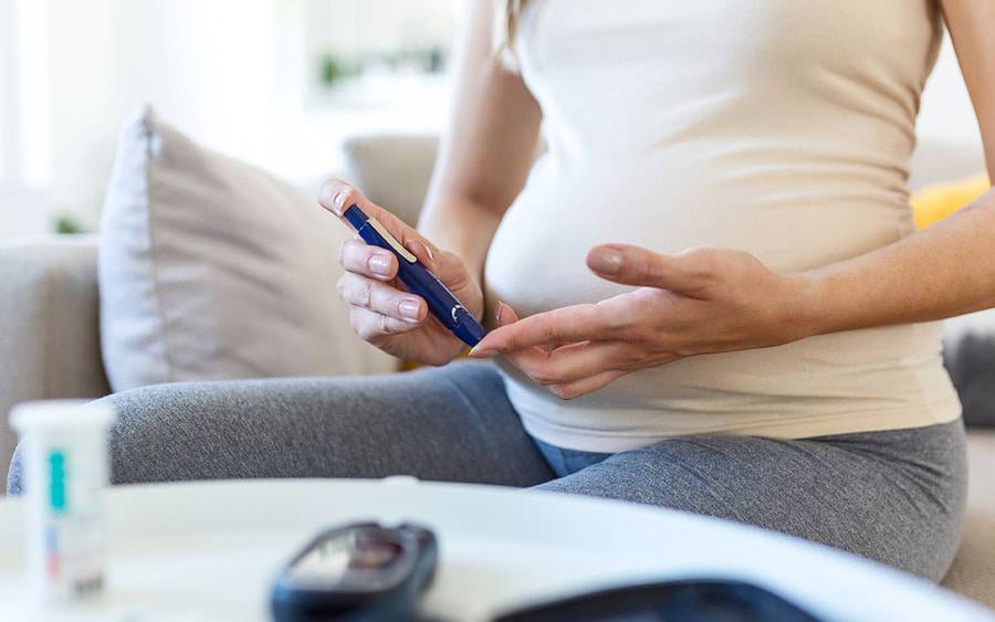 An expectant mother tests her blood sugar level. She has gestational diabetes.