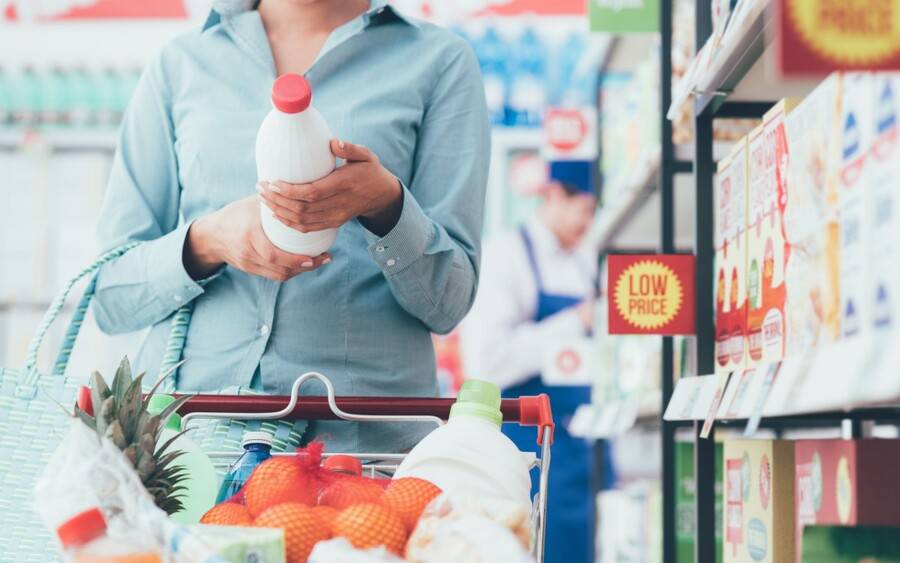 A shopper reads the nutrition fact label on a grocery product.