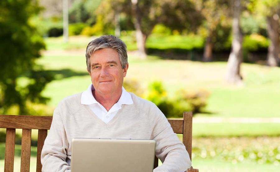 A smiling middle-aged man in a park represents the full life that can be led after retroperitoneal sarcoma treatment.