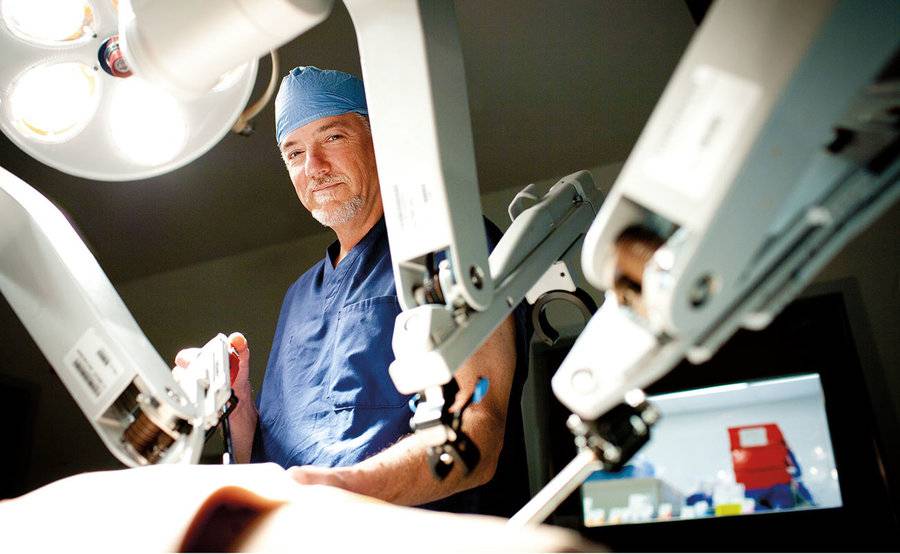 A doctor operates a minimally invasive robotic surgery system in an operating room, representing advanced robotic cardiothoracic surgery at Scripps.
