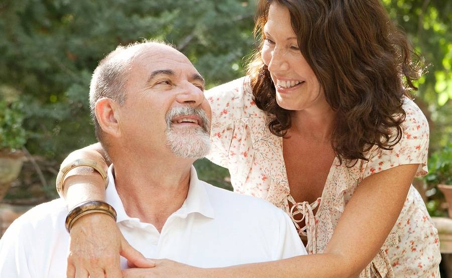 Mature woman and man hugging outdoors