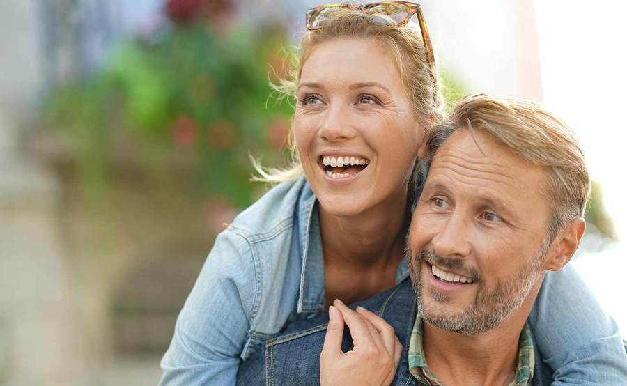 A smiling young Caucasian couple represent the full life that can be led after cancer screening and treatment.