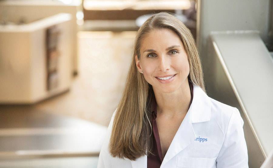 A Scripps genetic counselor in a white lab coat represents the expert genetic counseling offered at Scripps Cancer Center.